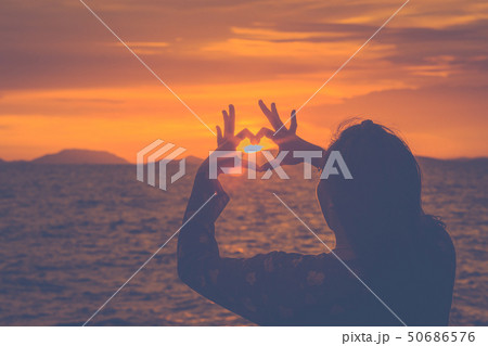 Silhouette woman hand is making a heart-shaped 50686576
