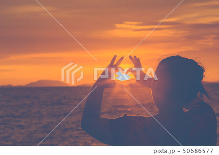 Silhouette woman hand is making a heart-shaped 50686577