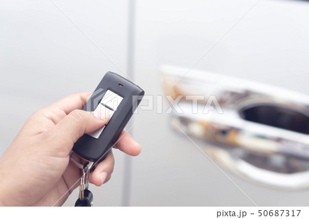 Closeup woman hand holding car key remote Closeup woman hand holding car key remote 50687317