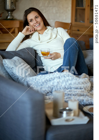 woman relaxes home and drinks tea with lemon 50691471