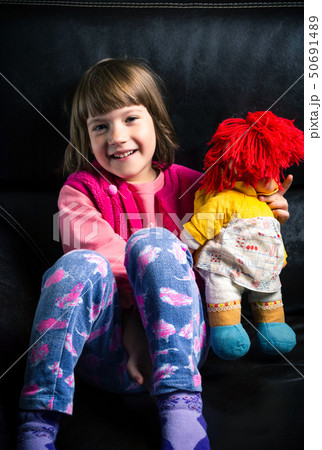 Cute girl with her toy on the sofa Cute girl with her toy on the sofa 50691489