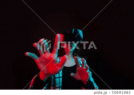 Portrait of surprised young girl using modern virtual reality headset in studio Portrait of surprised young girl using modern virtual reality headset in studio 50691983
