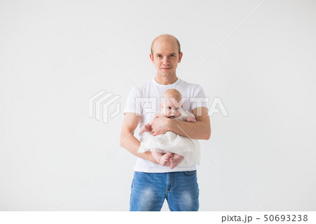 Children, family and fatherhood concept - happy bald father holding baby daughter on white Children, family and fatherhood concept - happy bald father holding baby daughter on white 50693238