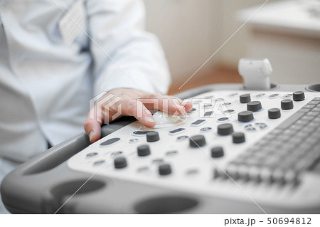 The doctor holds an ultrasound on the patient, a hand close up The doctor holds an ultrasound on the patient, a hand close up 50694812
