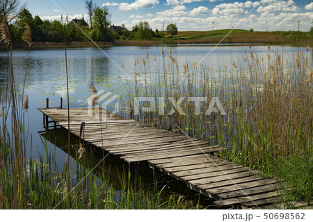 Old rustic wooden jetty on a tranquil lake 50698562