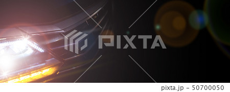 Headlight of a modern car in dense fog against dark background 50700050