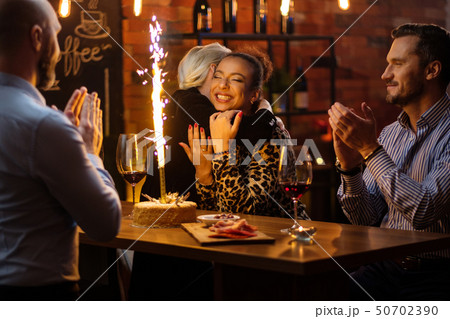 Group of friends celebrating birthday in a cafe behind bar counter Group of friends celebrating birthday in a cafe behind bar counter 50702390