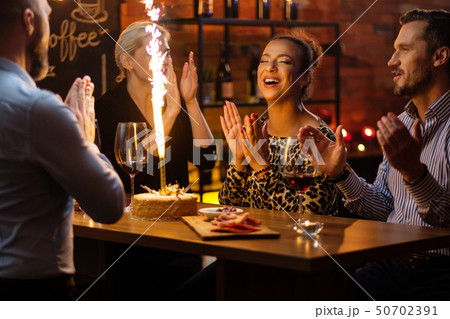 Group of friends celebrating birthday in a cafe behind bar counter Group of friends celebrating birthday in a cafe behind bar counter 50702391