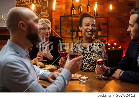 Group of friends having fun talk behind bar counter in a cafe Group of friends having fun talk behind bar counter in a cafe 50702412