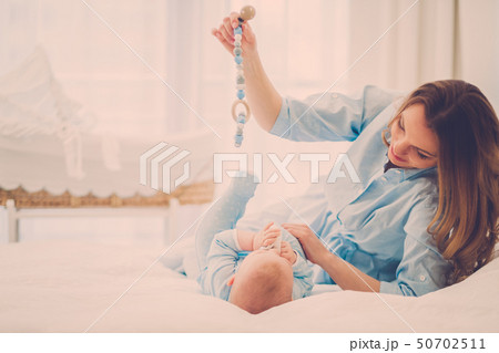 Happy middle aged mother with her child in a bed Happy middle aged mother with her child in a bed 50702511