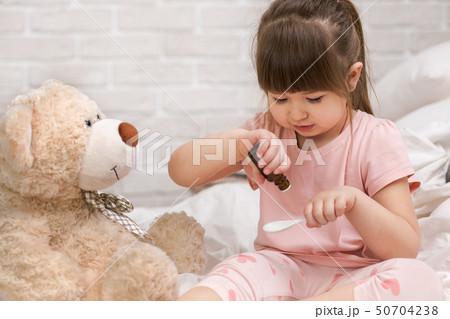 cute child girl playing doctor with teddy bear cute child girl playing doctor with teddy bear 50704238