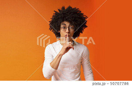 Black millennial guy putting finger to lips 50707786