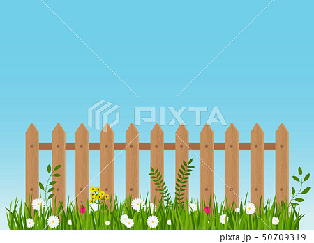 A wooden fence, a hedge near with a flower bed. 50709319
