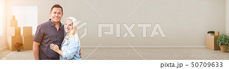 Happy Couple Inside Empty Room with Boxes Banner 50709633