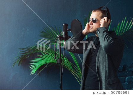 Close up of a man singer in a headphones recording Close up of a man singer in a headphones recording 50709692