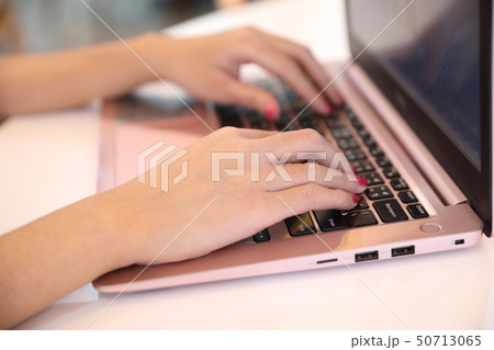 Woman hand working at coffee shop hand on keyboard with close up 50713065