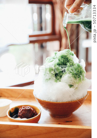 Delicious Japanese sweet shaved ice green tea on wooden table in japanese cafe Delicious Japanese sweet shaved ice green tea on wooden table in japanese cafe 50713334