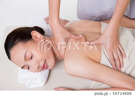 Body Massage on specific naked back of Asian woman by pressing fingers on pain or stress muscle point to release relax.  Therapist Spa body massage woman hands treatment on customer, isolated on whit 50714606