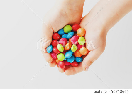 Multicolored candies in the hands of a child on a 50718665