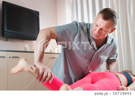 Male manual visceral therapist masseur treats a young female patient. Work with the buttocks of the Male manual visceral therapist masseur treats a young female patient. Work with the buttocks of the 50719943