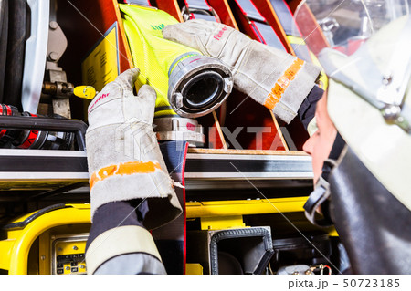Fire fighters attaching hose at hose laying vehicle Fire fighters attaching hose at hose laying vehicle 50723185