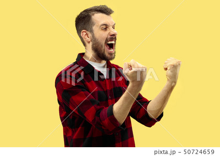 Half-length close up portrait of young man on yellow background. 50724659