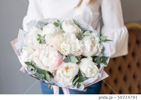 White peonies with eucalyptus in womans hand. Beautiful peony flower for catalog or online store White peonies with eucalyptus in womans hand. Beautiful peony flower for catalog or online store 50724791