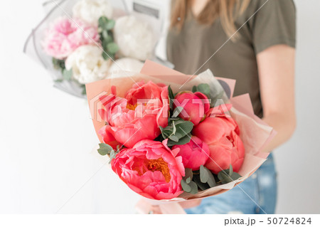 Two Beautiful bouquets. Coral and white peonies in womans hand. Beautiful peony flower for catalog 50724824