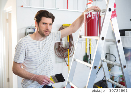 Male painter standing near ladder in workshop Male painter standing near ladder in workshop 50725661