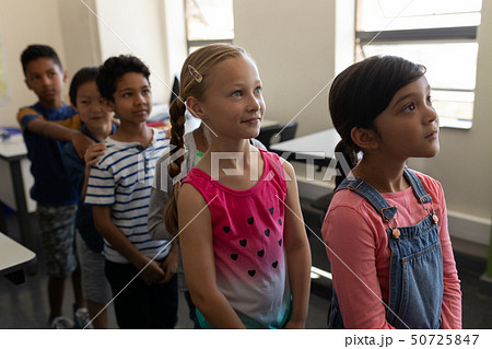 School kids standing in row in classroom of elementary school 50725847