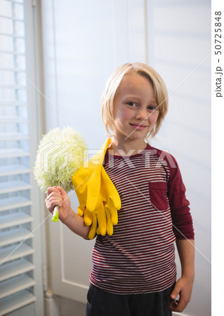 Boy holding a mop at home 50725848