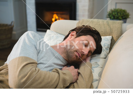 Man sleeping on sofa in living room Man sleeping on sofa in living room 50725933