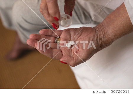 Senior woman having medicine in bedroom 50726012