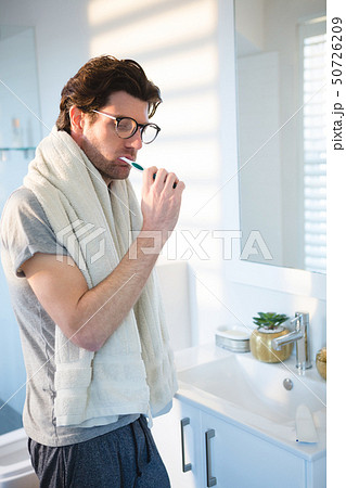 Man brushing his teeth in bathroom 50726209