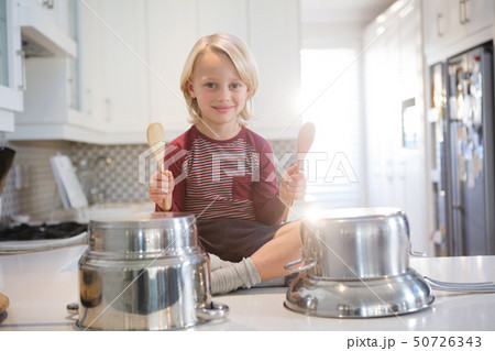 Boy playing with utensils in kitchen Boy playing with utensils in kitchen 50726343