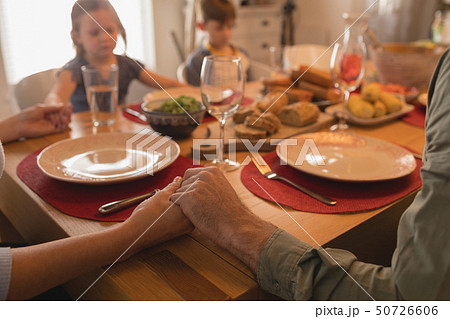 Family praying before having food on dining table Family praying before having food on dining table 50726606