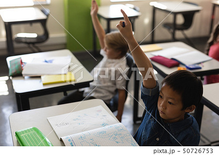 Schoolboy raising hand in classroom Schoolboy raising hand in classroom 50726753