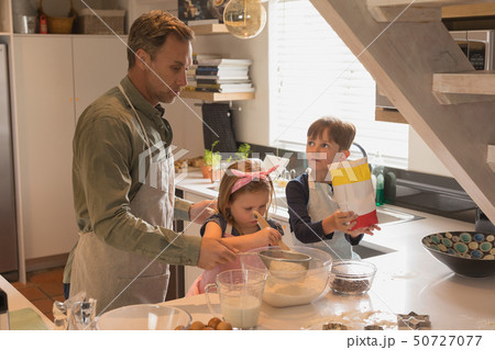 Father with his children preparing food in kitchen Father with his children preparing food in kitchen 50727077