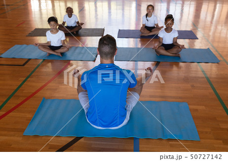 Yoga teacher teaching yoga to school kids in school Yoga teacher teaching yoga to school kids in school 50727142