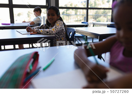 School kids sitting and working in classroom 50727260
