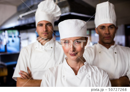 Group of chefs standing with arms crossed in kitchen Group of chefs standing with arms crossed in kitchen 50727268