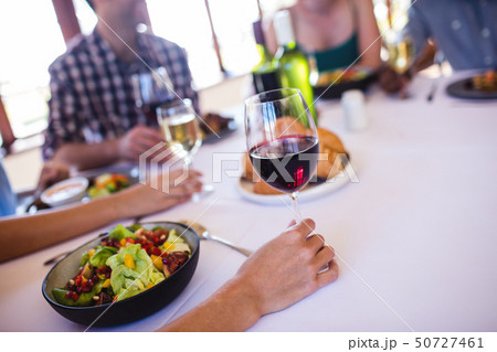 Woman holding wine glass in restaurant Woman holding wine glass in restaurant 50727461