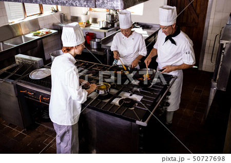 Group of chefs preparing food in kitchen 50727698