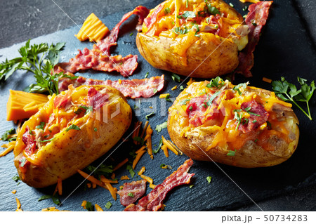 Loaded freshly Baked Potatoes on a stone tray Loaded freshly Baked Potatoes on a stone tray 50734283
