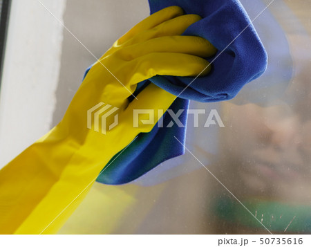 Person using cloth to clean window glass 50735616