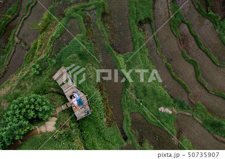 Aerial view on top. Two lovers of young people lie on a wooden bridge. Happy couple traveling at Aerial view on top. Two lovers of young people lie on a wooden bridge. Happy couple traveling at 50735907