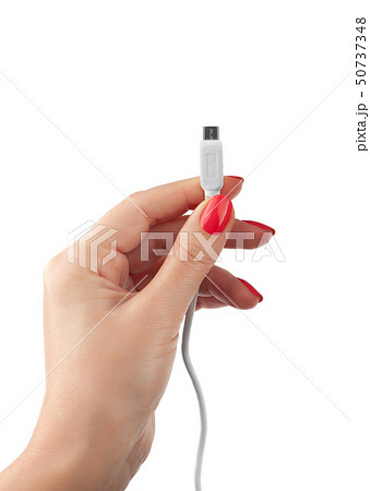 Hand holding USB cable. Female hand holding charging cable Hand holding USB cable. Female hand holding charging cable 50737348