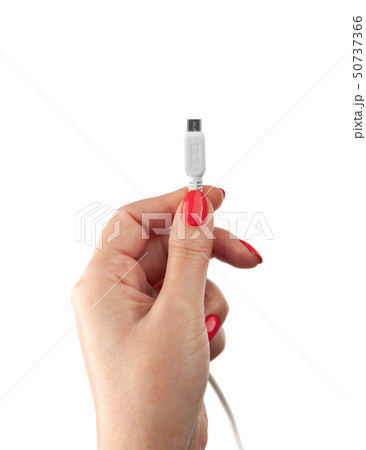Hand holding USB cable. Female hand holding charging cable Hand holding USB cable. Female hand holding charging cable 50737366