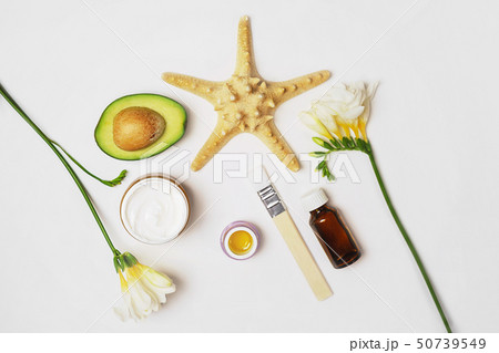 Beauty concept avocado, skin care facial essence oil, brush, lily flower and towel on white Beauty concept avocado, skin care facial essence oil, brush, lily flower and towel on white 50739549