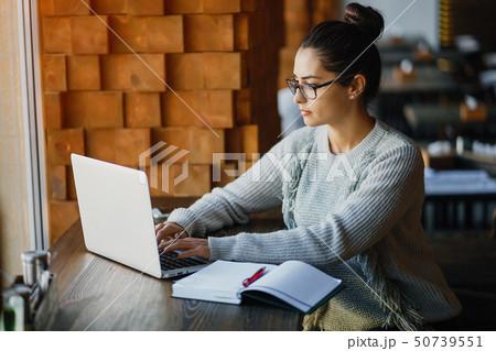 girl working on a laptop at a restaurant 50739551